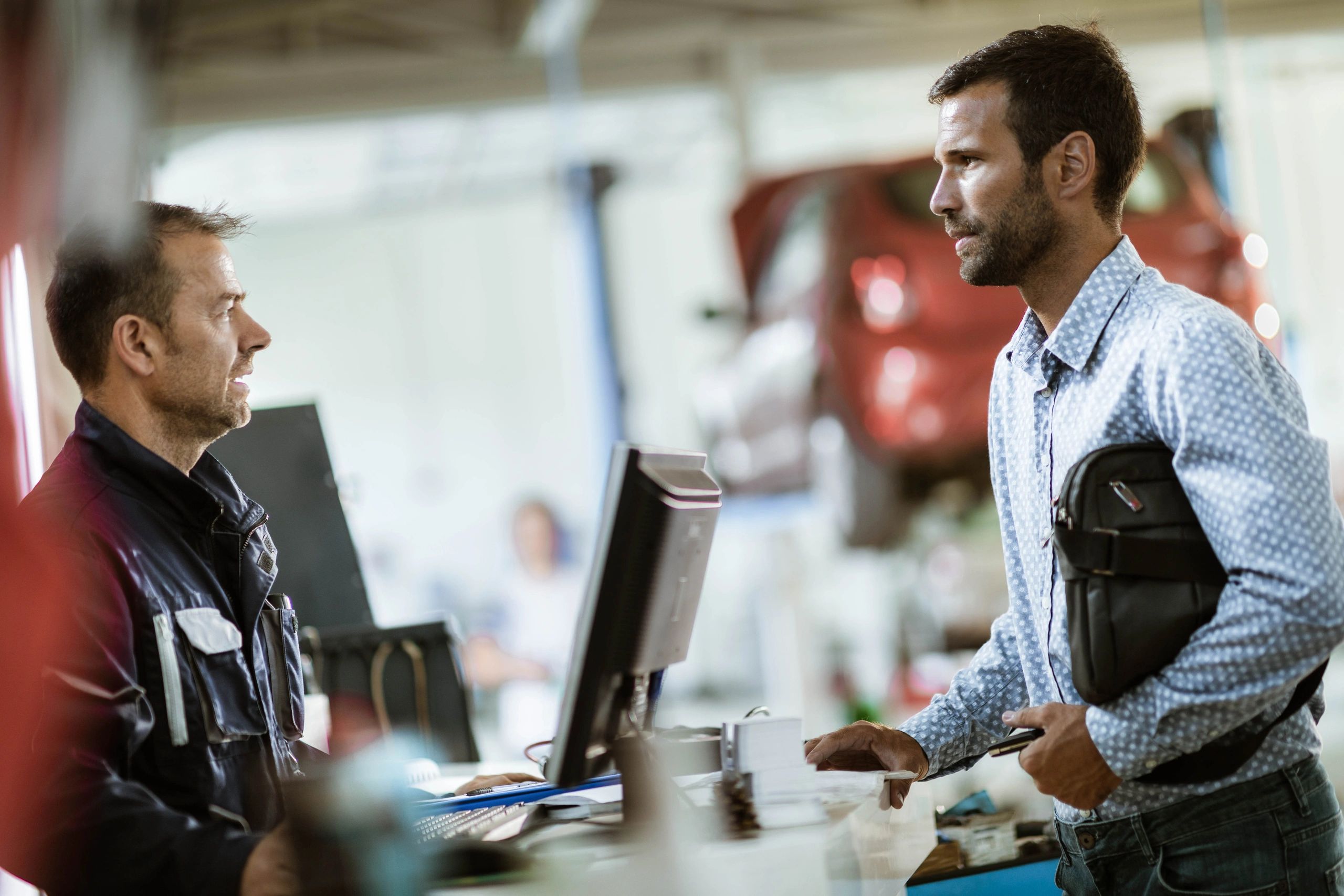 Customer speaking with a mechanic at an auto repair shop