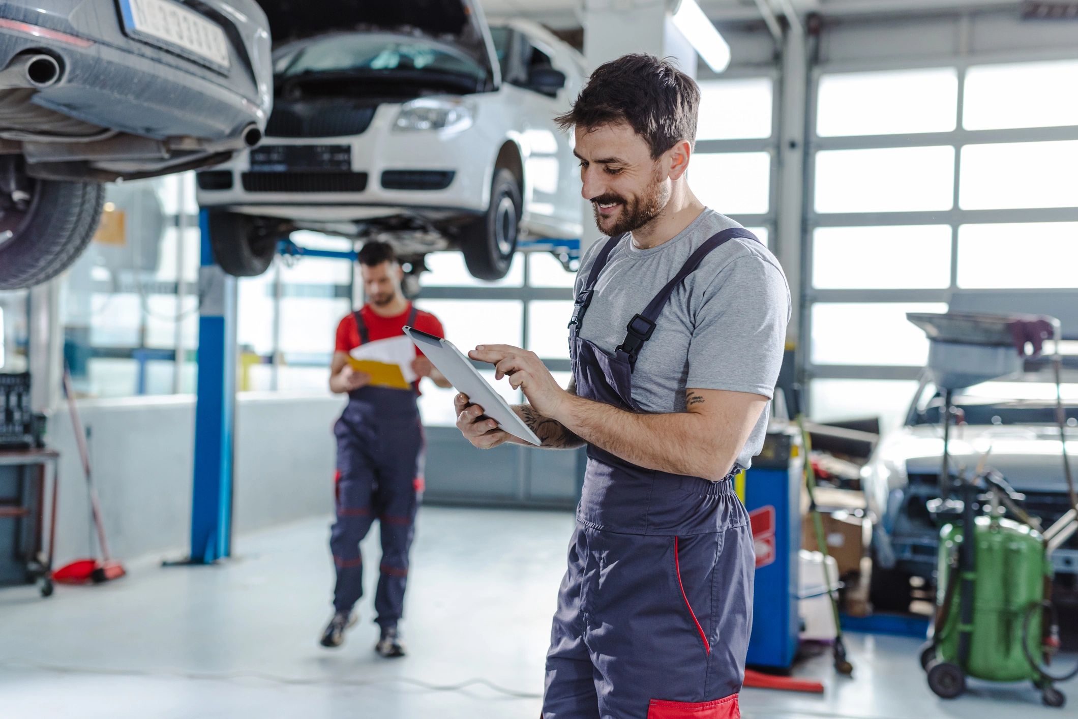 Automotive technician holding a digital tablet in a service station