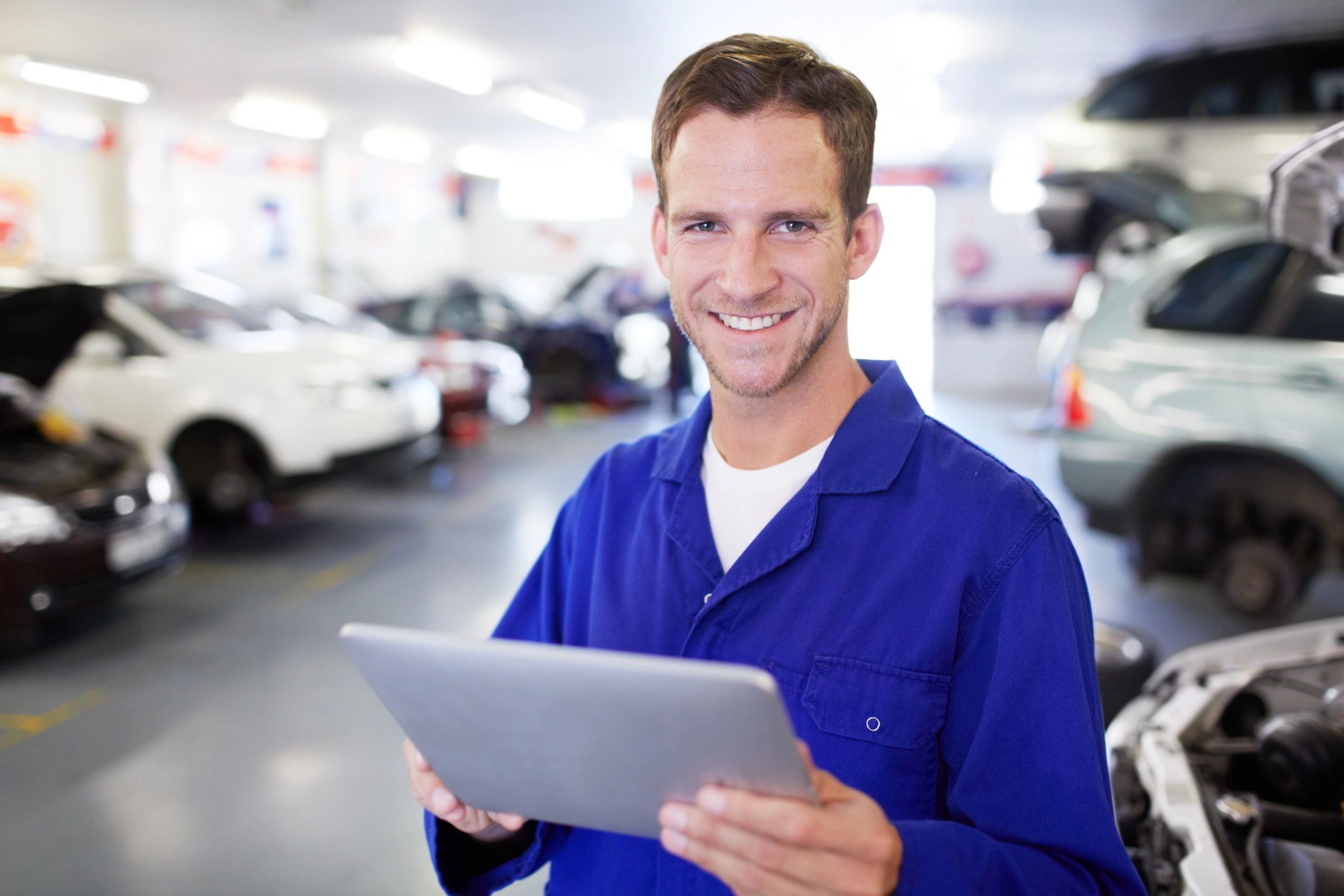 Mechanic using a digital tablet in an auto repair shop