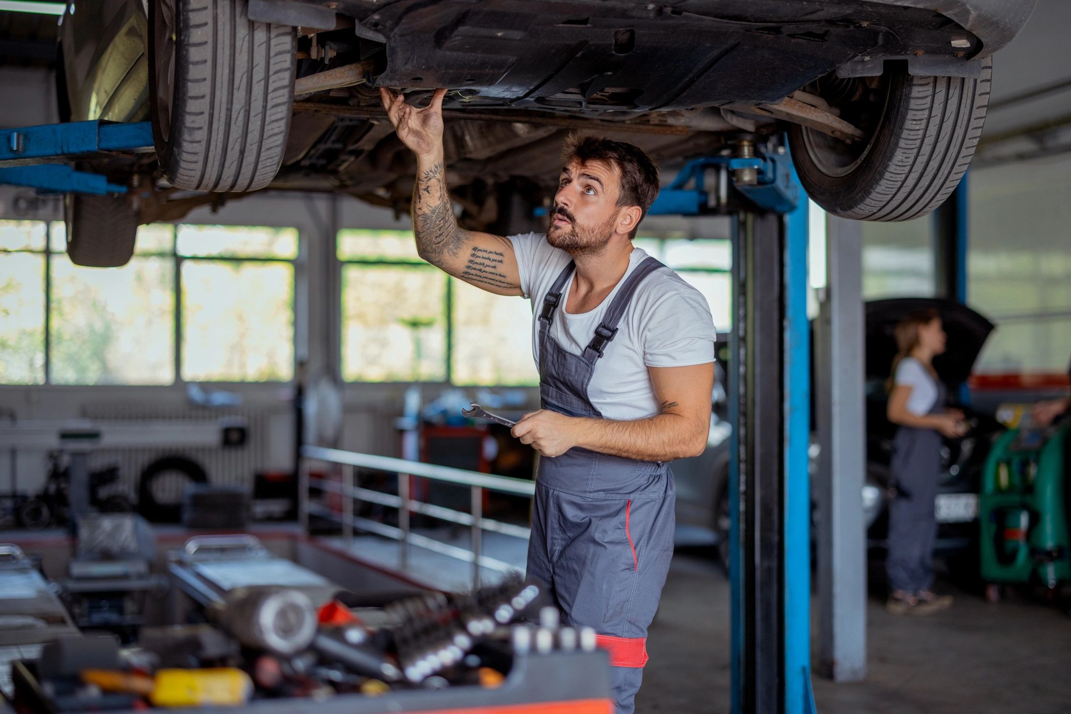 Mechanic checking a car undercarriage in a repair shop