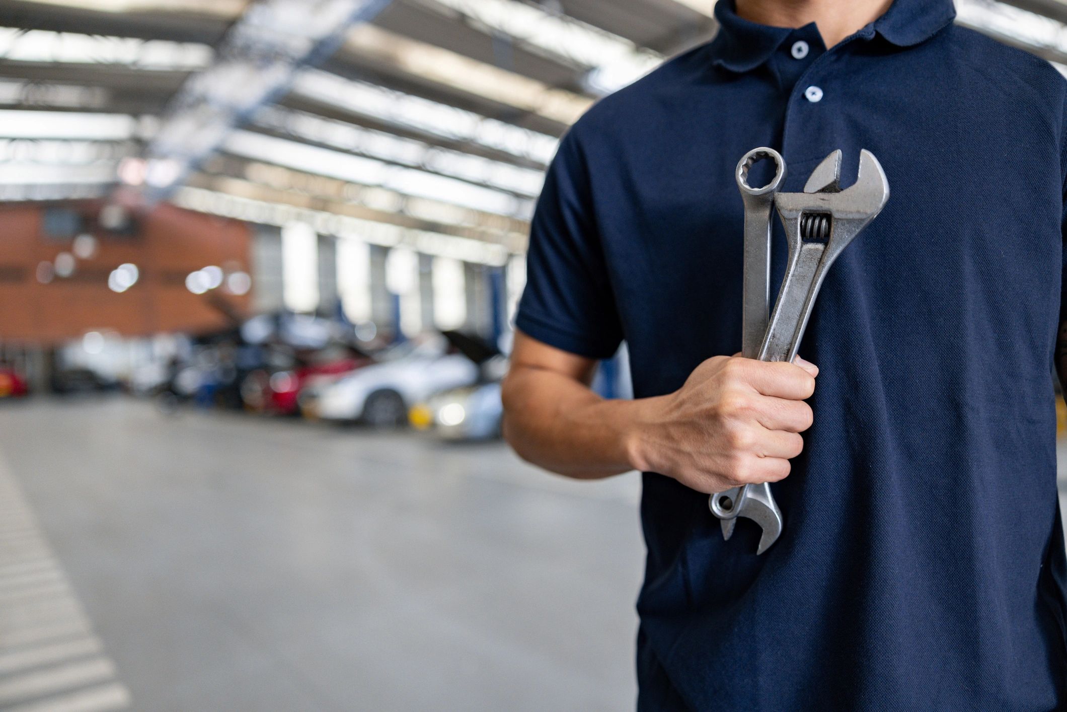 Mechanic working in an auto repair shop holding tools