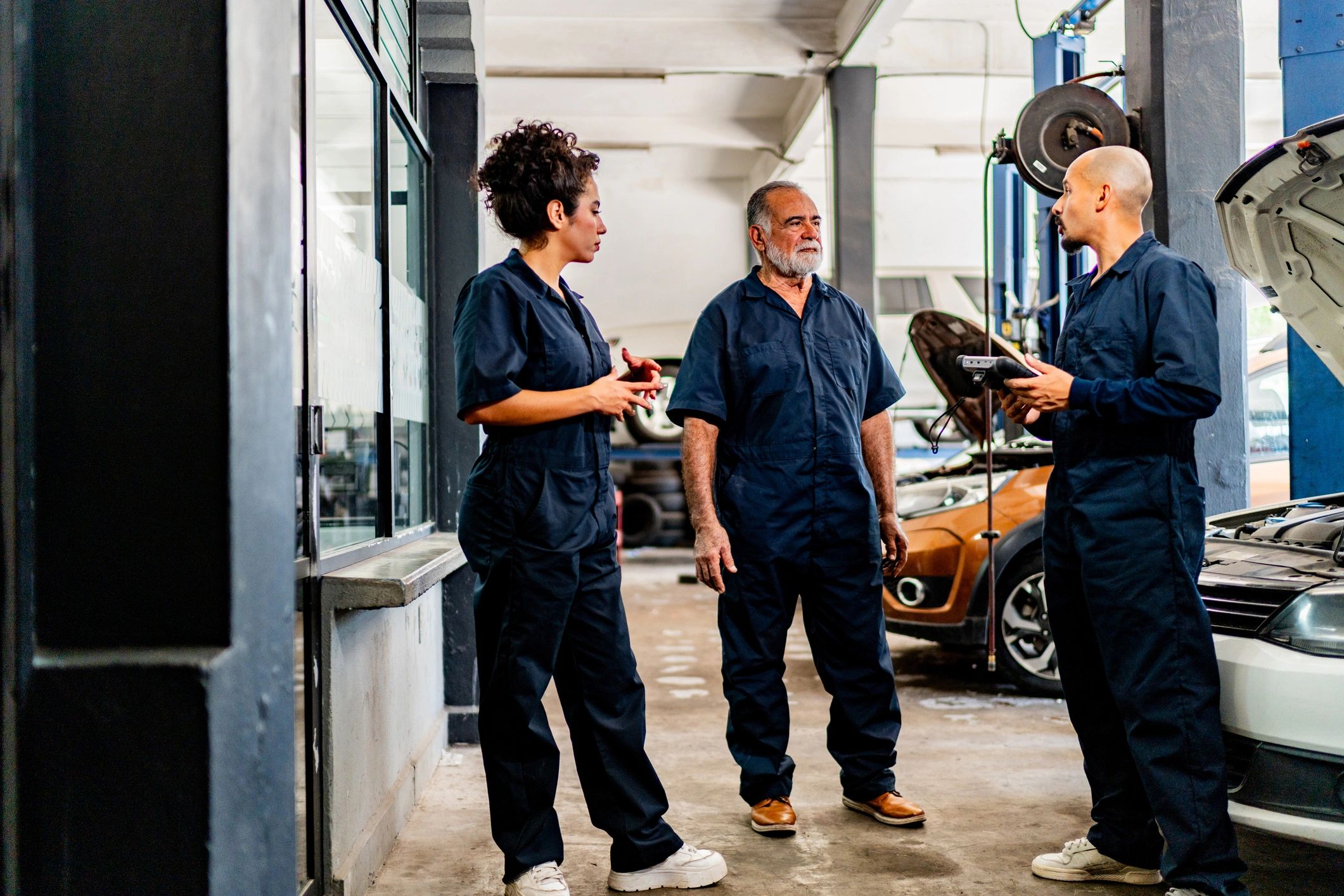 Mechanics discussing a repair plan in an auto repair shop