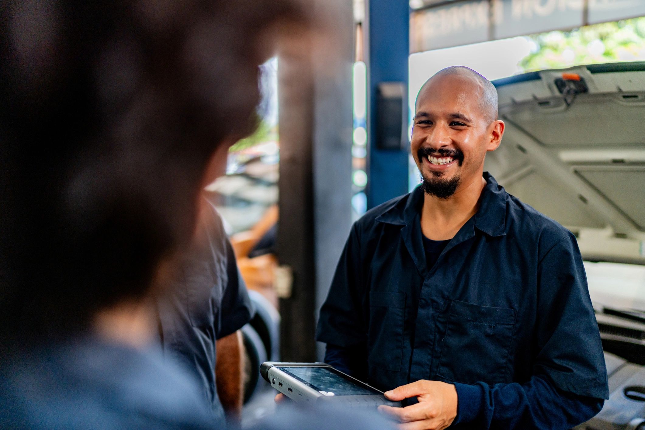 Mechanic speaking with coworkers at an auto repair shop