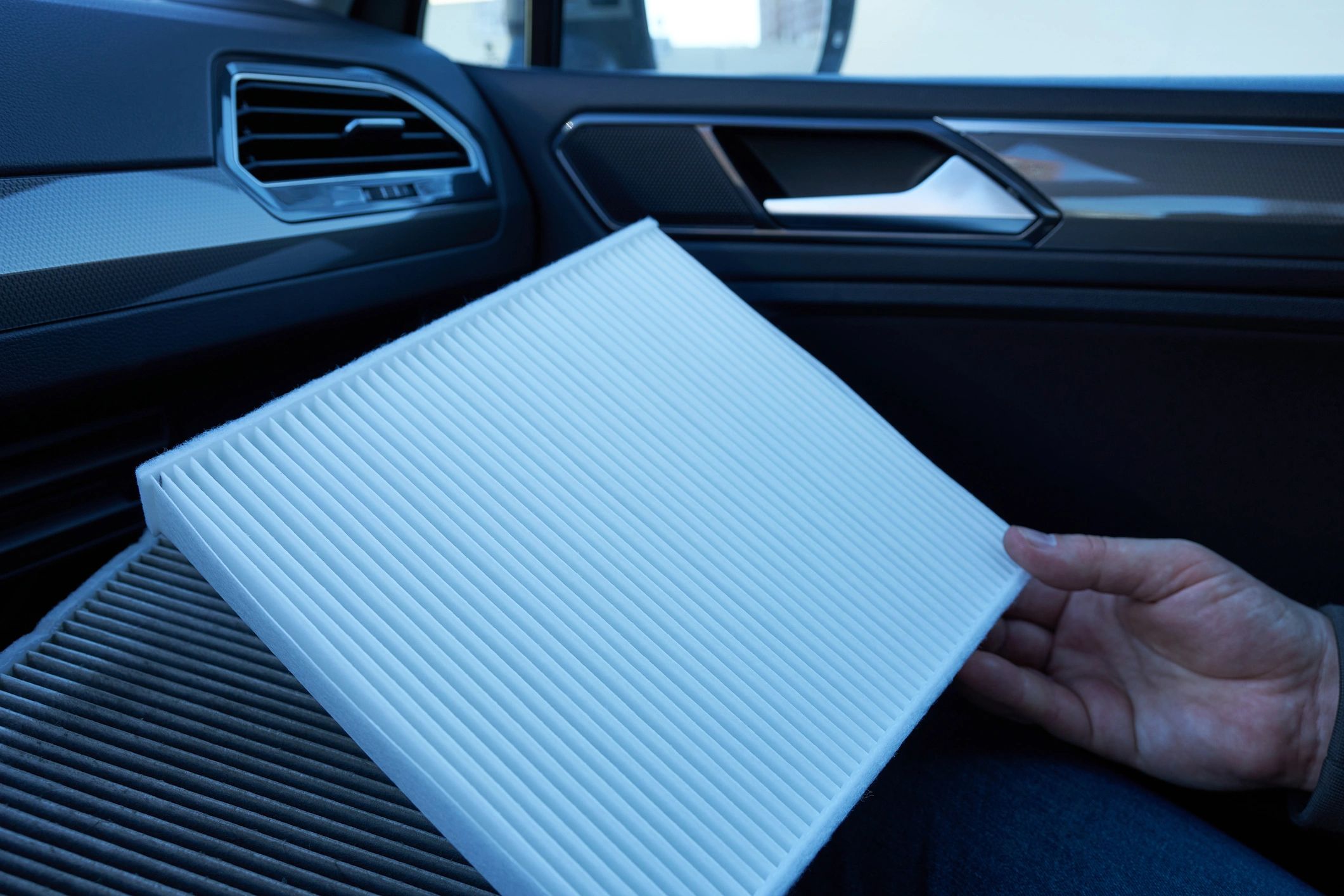 Close-up of a car cabin air filter being replaced