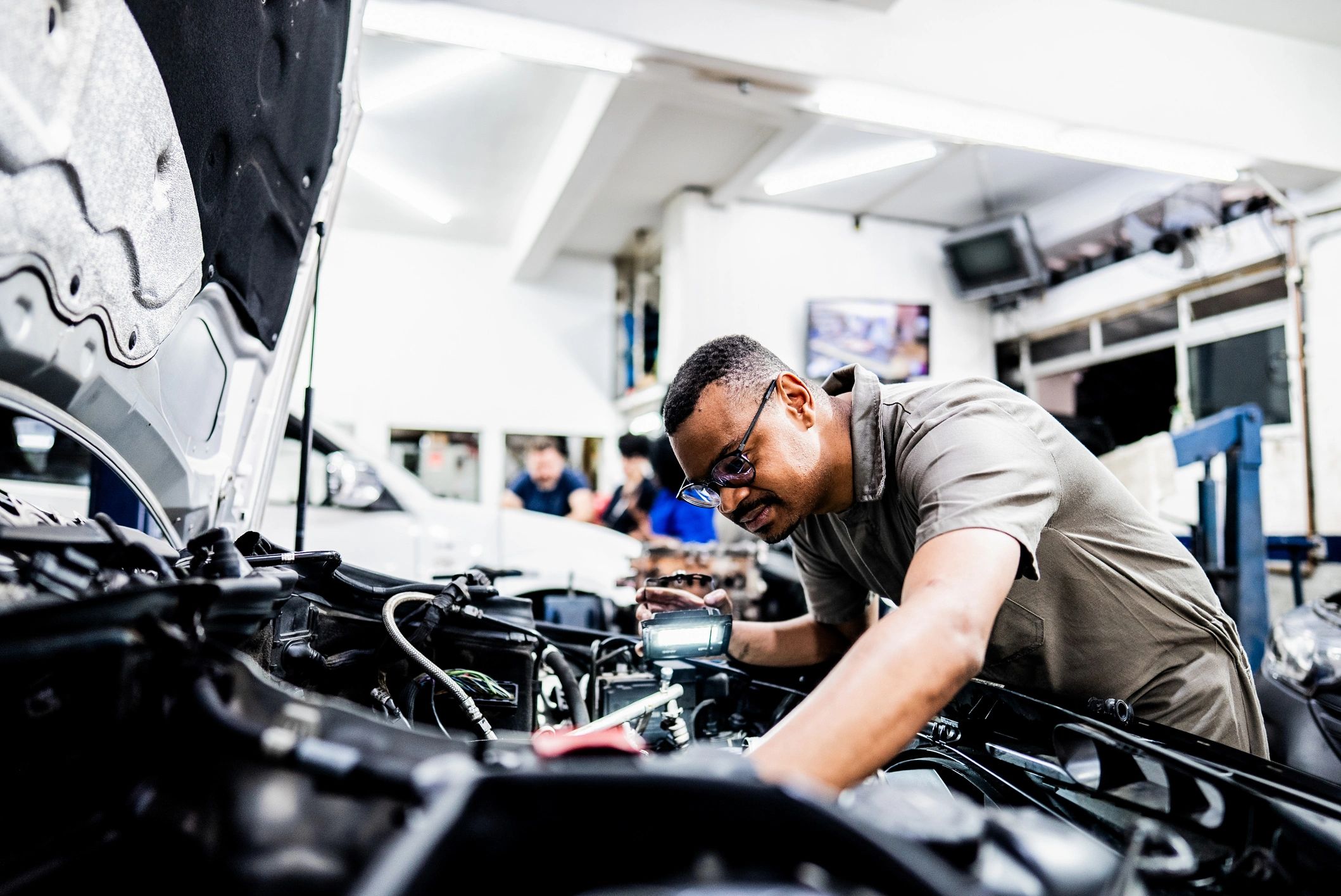 Mechanic inspecting a vehicle in a repair shop