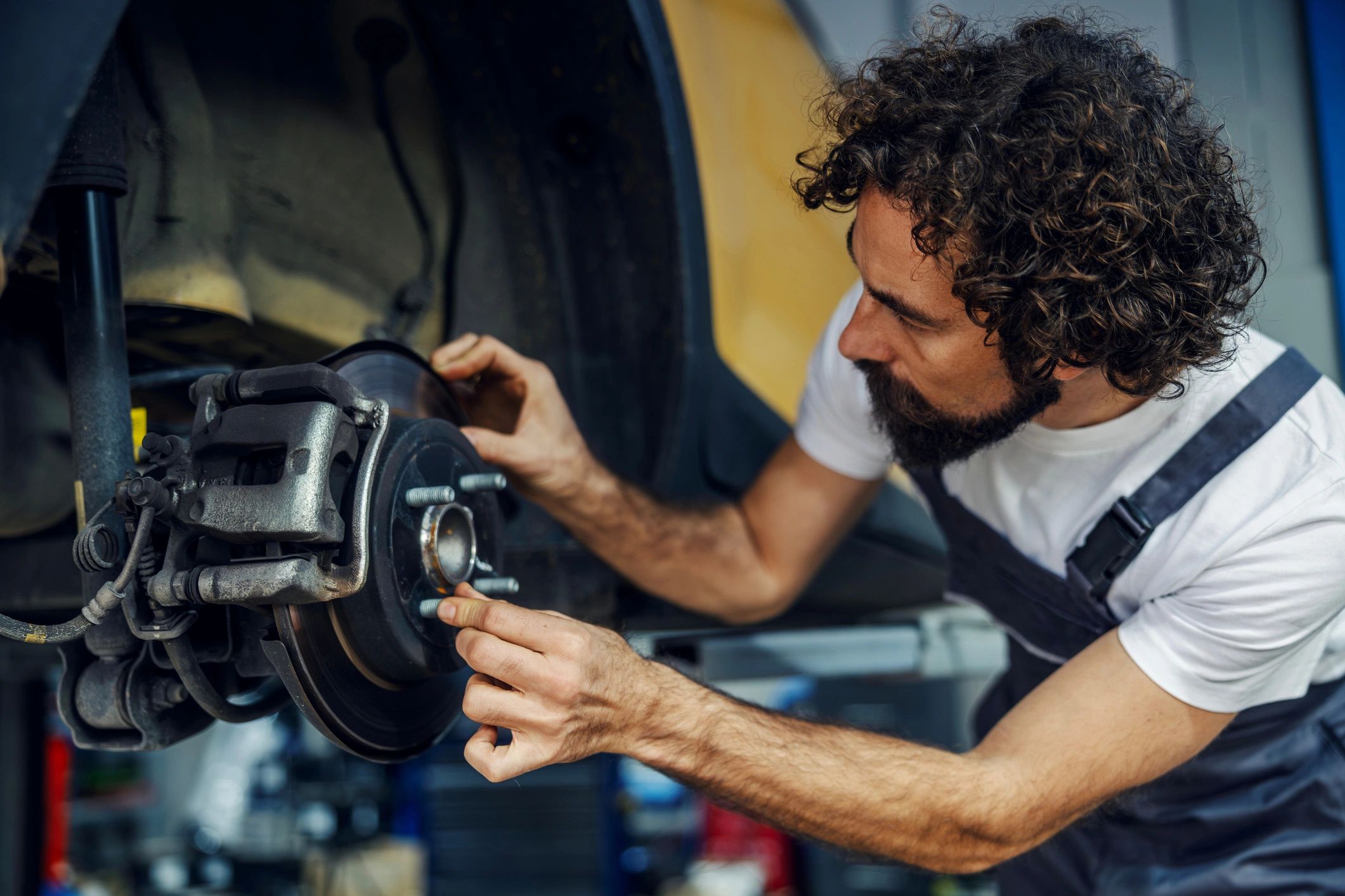 Mechanic repairing a car brake system in a garage