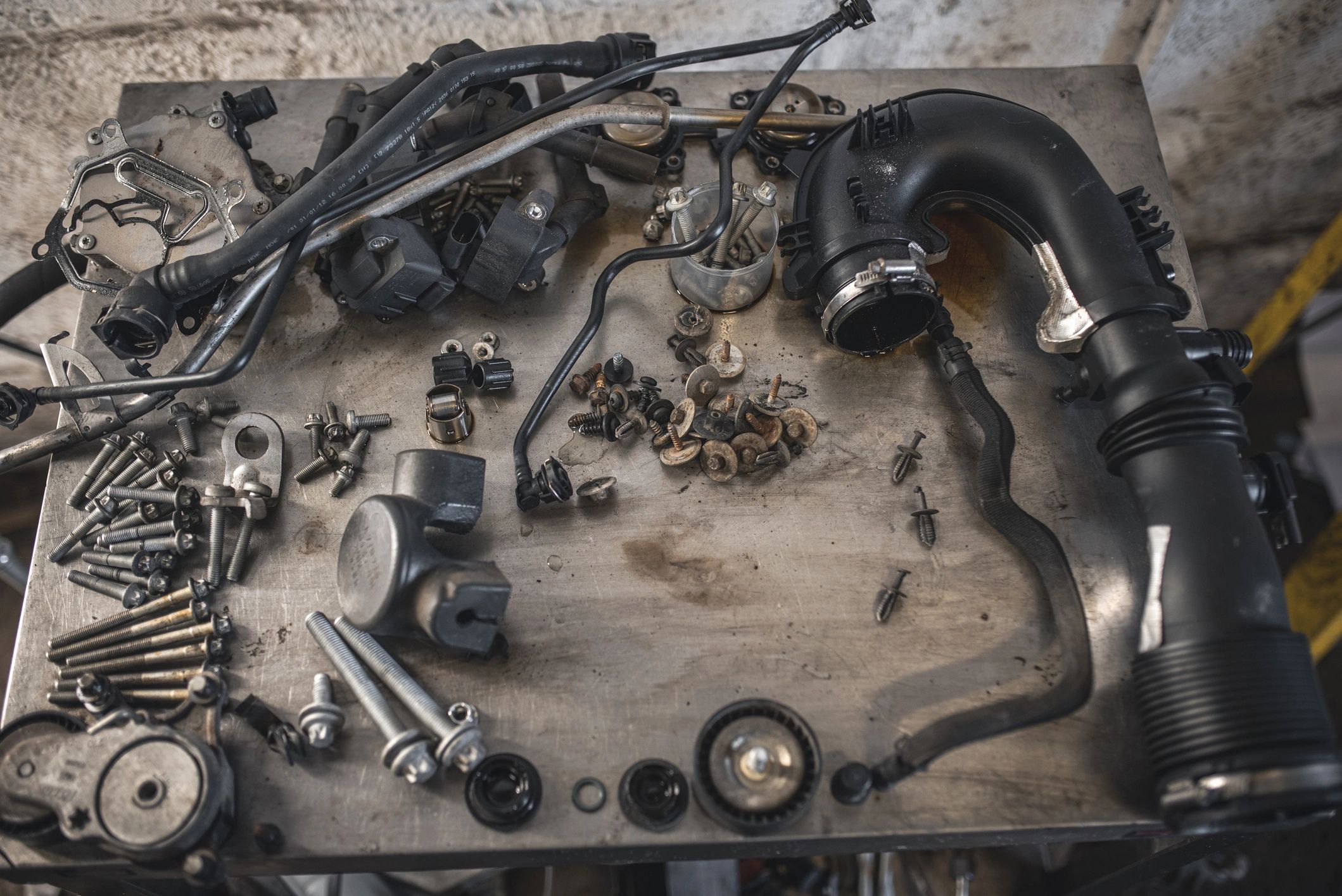 Disassembled car engine parts arranged on a workbench
