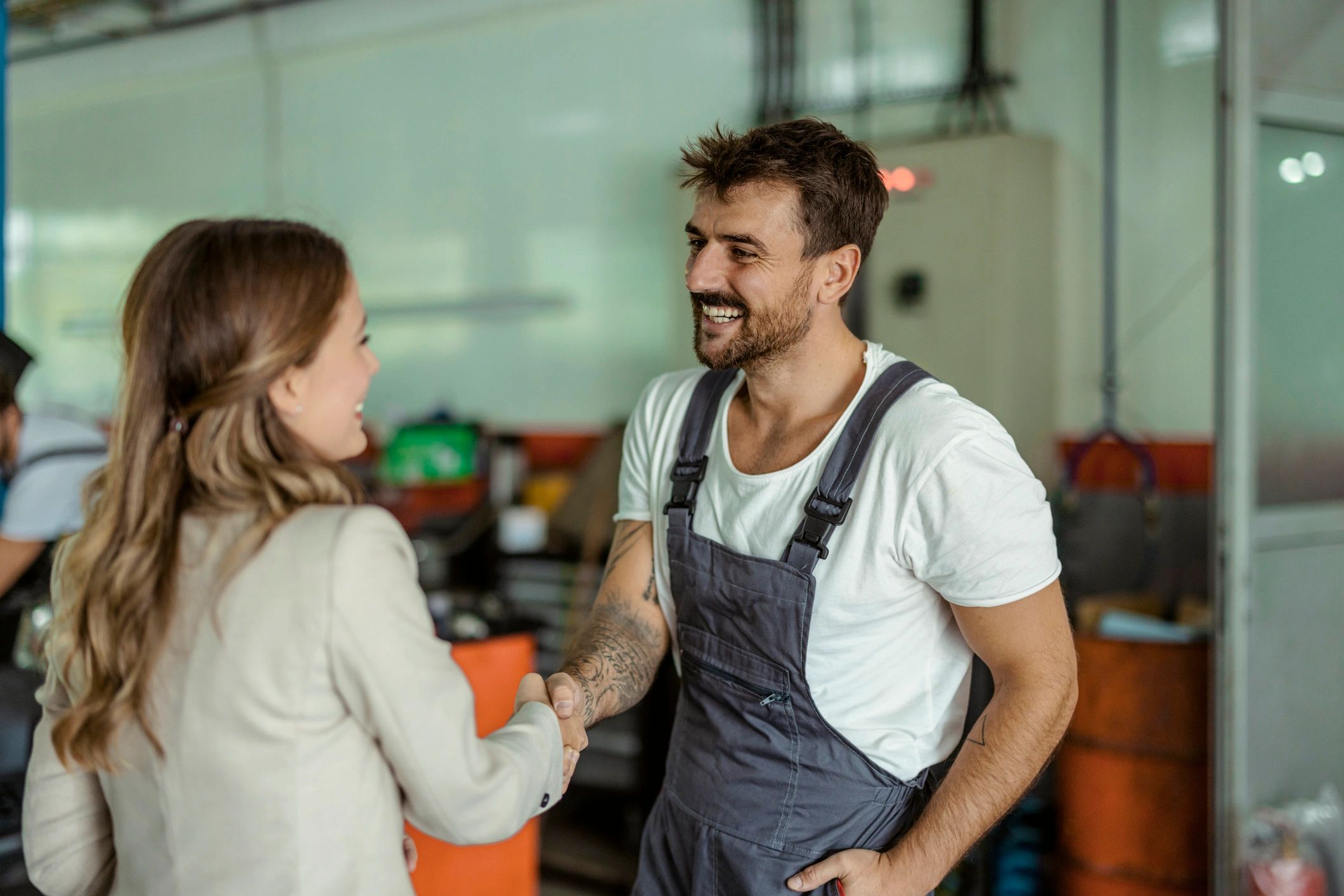 Mechanic and customer handshake after car service in a garage